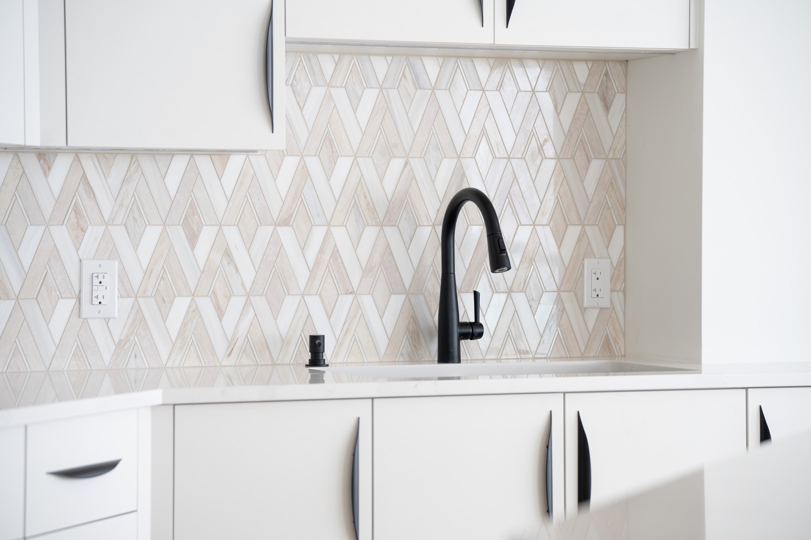 kitchen cabinets with patterned backsplash and sink