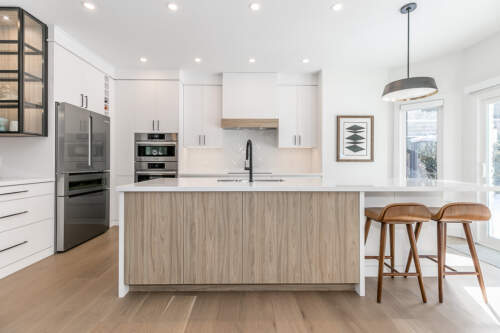 a view of the back of the island in the foreground and the perimeter of the kitchen in the background