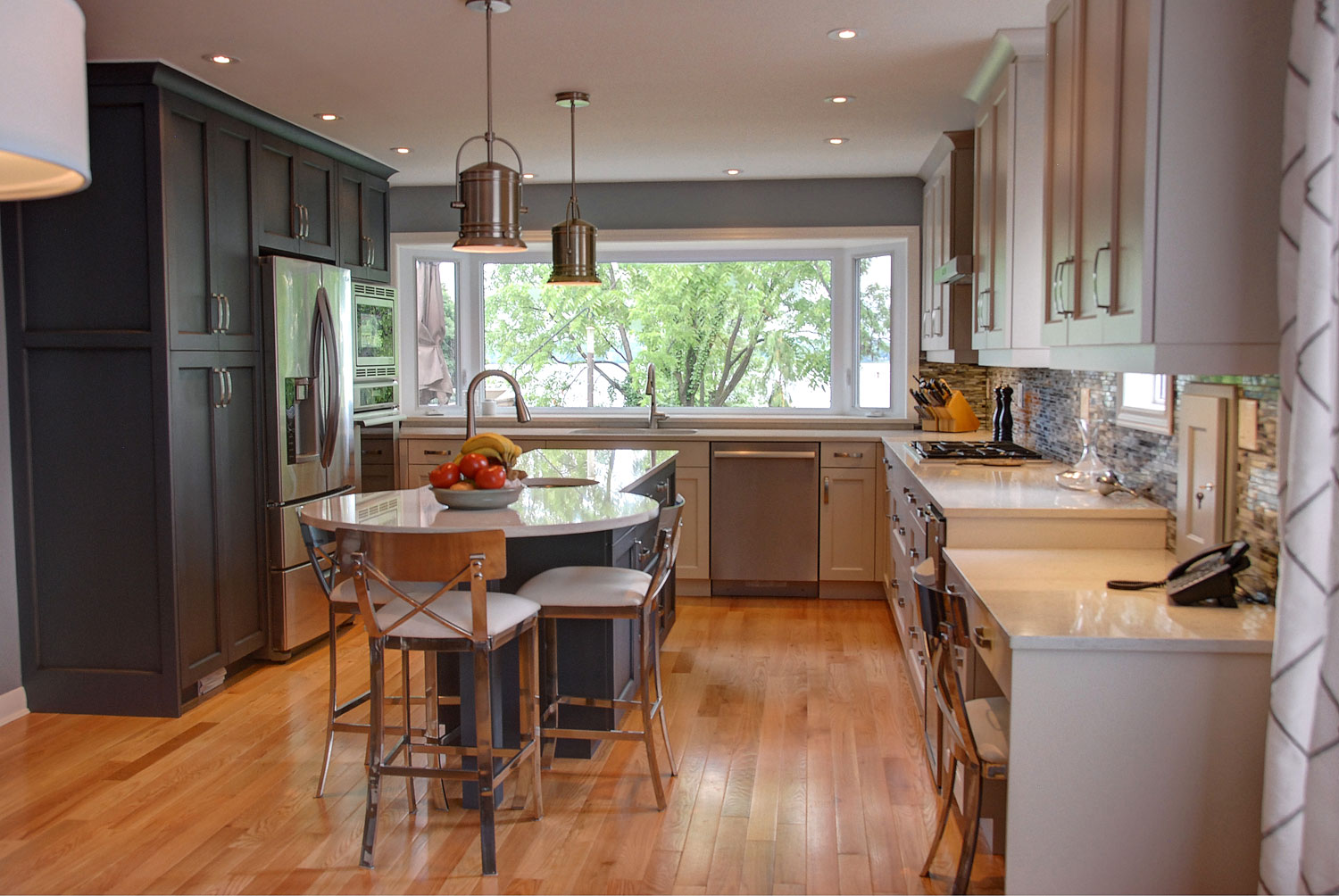 Lakefront cottage kitchen design and renovation with two tone cream and grey blue cabinets, a large island, stainless steel appliances, and hardwood floors - Total Living Concepts in Barrie Ontario