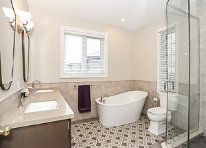 Gorgeous ensuite design with dual sinks, freestanding tub, stand up glass shower with rock floor, and beautiful tile floor pattern - Total Living Concepts in barrie ontario