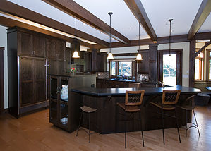 large kitchen design with dark wood cabinets, hardwood floors, stainless steel appliances, and wood ceiling beams - Total Living Concepts barrie ontario