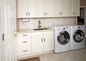 Laundry Room Renovation with cream colored cabinets and white appliances