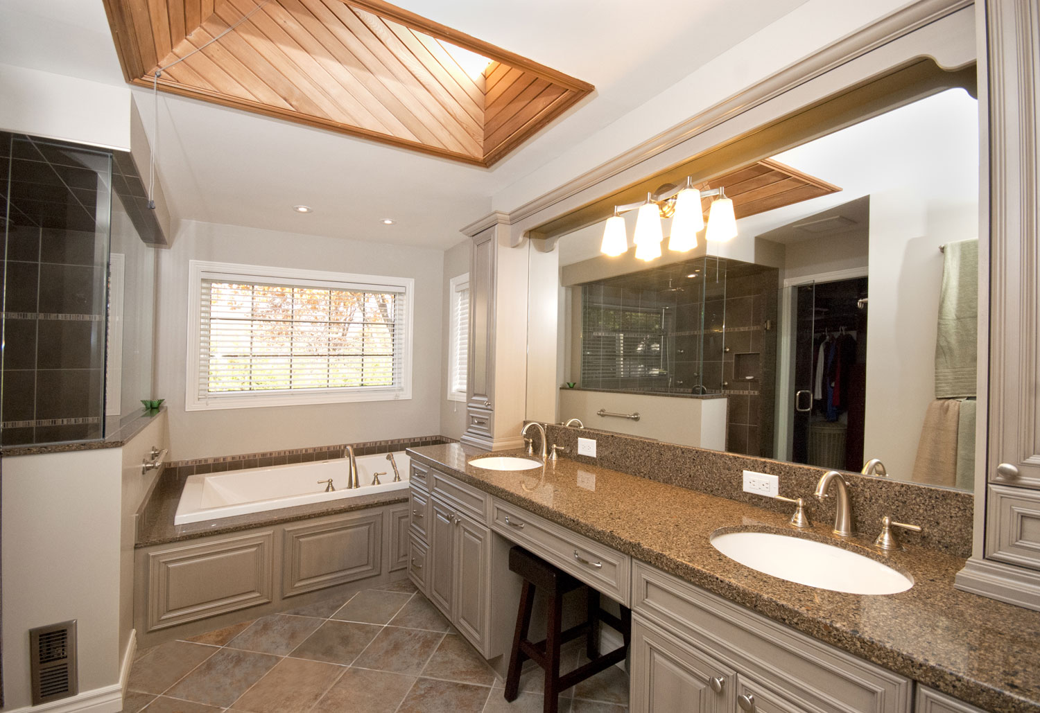 Large traditional ensuite design and renovation with dual sinks, makeup desk, large tub and separate walkin shower, skylight - Total Living Concepts barrie ontario